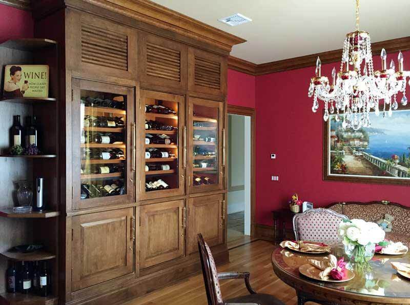 Custom bank of distressed wood refrigerated wine cabinets with illuminated wine display.