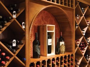 A unique wine display arch within a custom wine room showcases bottles of wine.