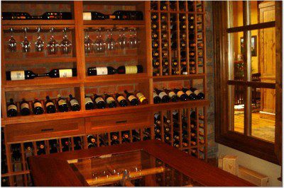 Custom wine cellar with viewing windows, racks, bins, reveals and Tuscan wine table