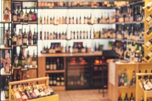 Wine shop with wine bottle racks. Abstract warm toned defocused background