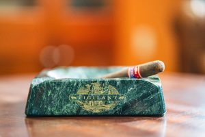 A fine cigar rests ina Vigilant branded green marble ashtray.